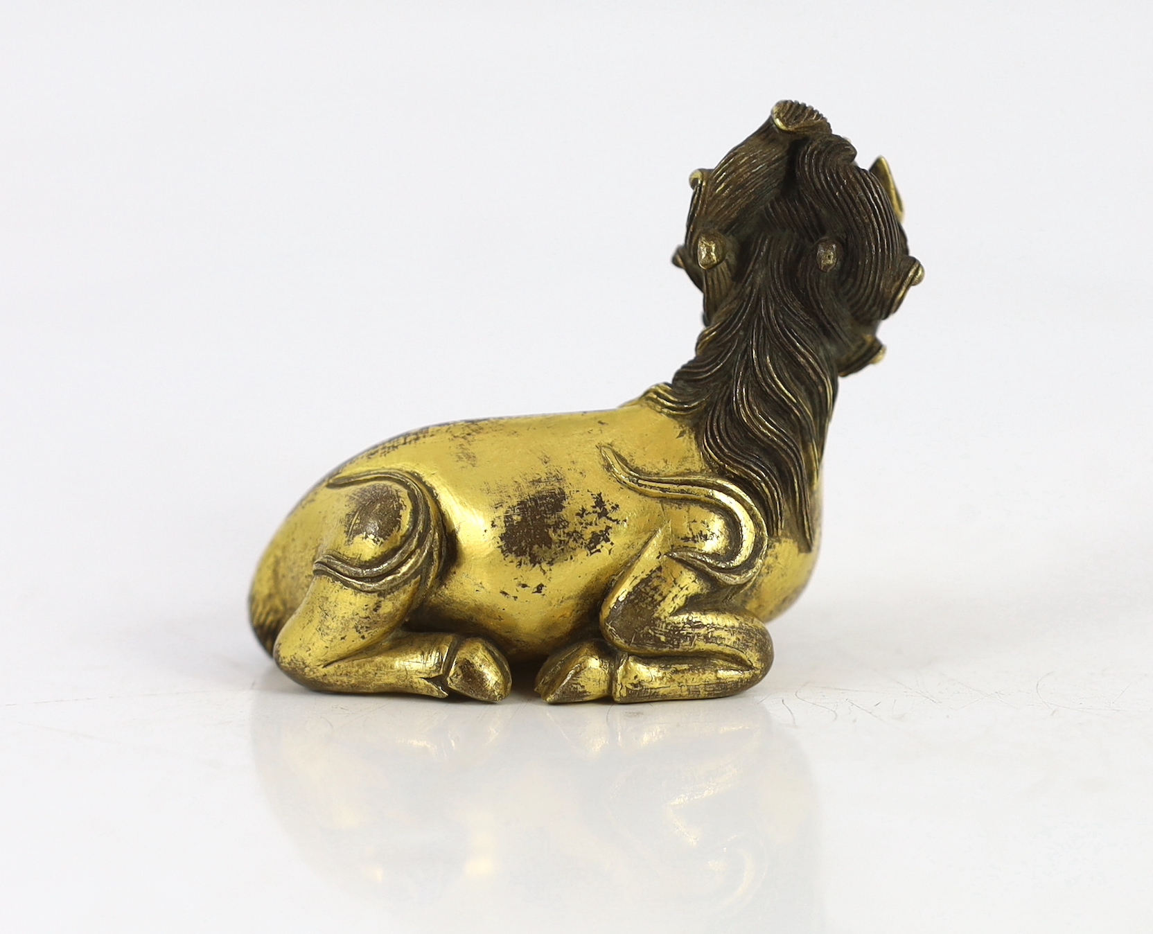 A Chinese gilt bronze qilin scroll weight, 17th/18th century, 7 cm across